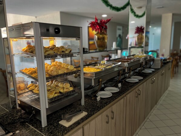 A buffet with multiple trays of baked goods and a variety of food options. - EL ARAM PONTA NEGRA (Natal)