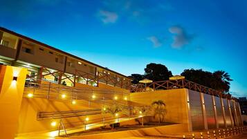 Edifício de hotel com vários níveis, escadas externas e área de piscina.