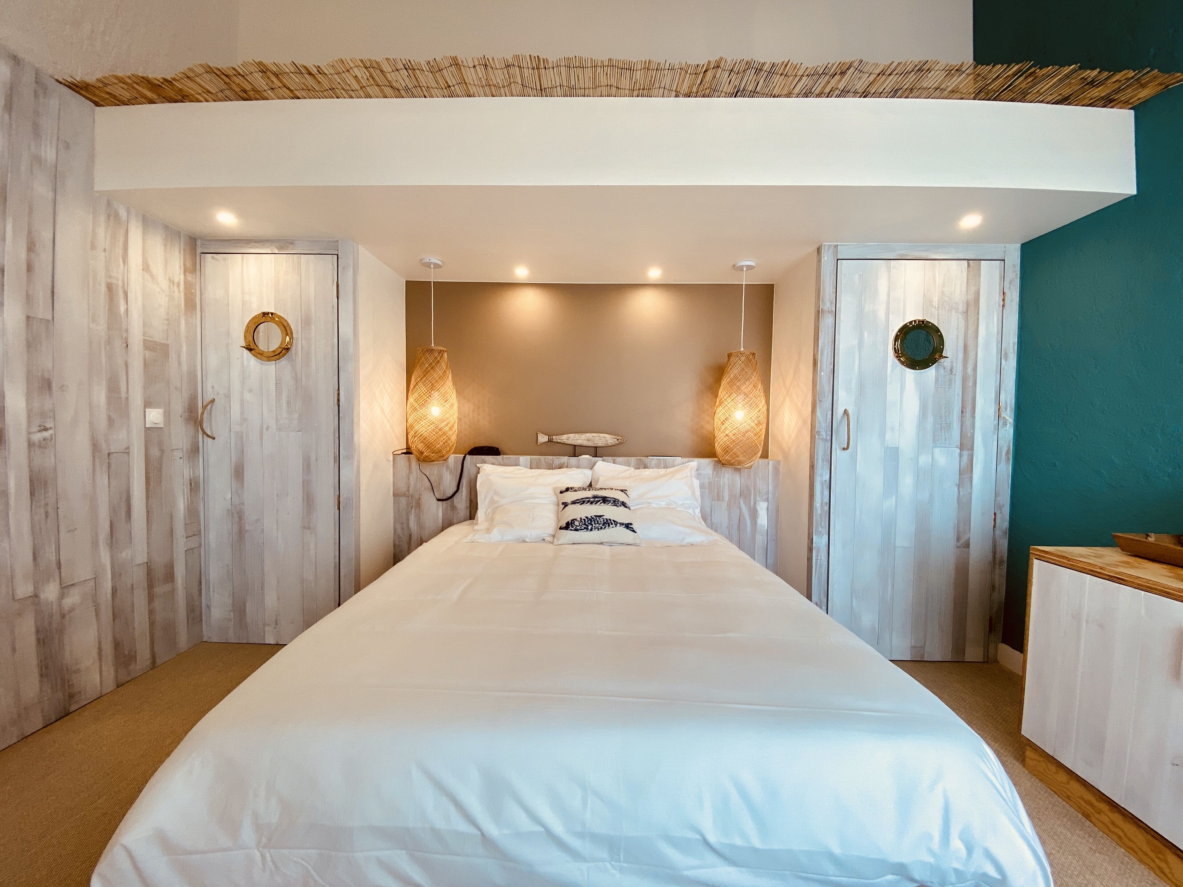 A bedroom with a large bed, two wall-mounted lamps, and a ceiling fan.