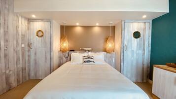 A bedroom with a large bed, two wall-mounted lamps, and a ceiling fan.