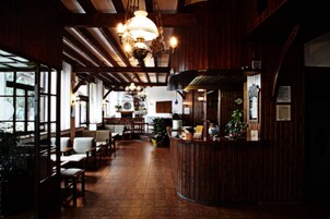 Un restaurante con interiores de madera, una barra y zonas de estar.
