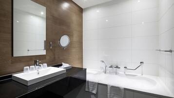 Un baño moderno con tocador doble, un espejo grande, un espejo redondo y una ducha a ras de suelo con puerta de cristal.