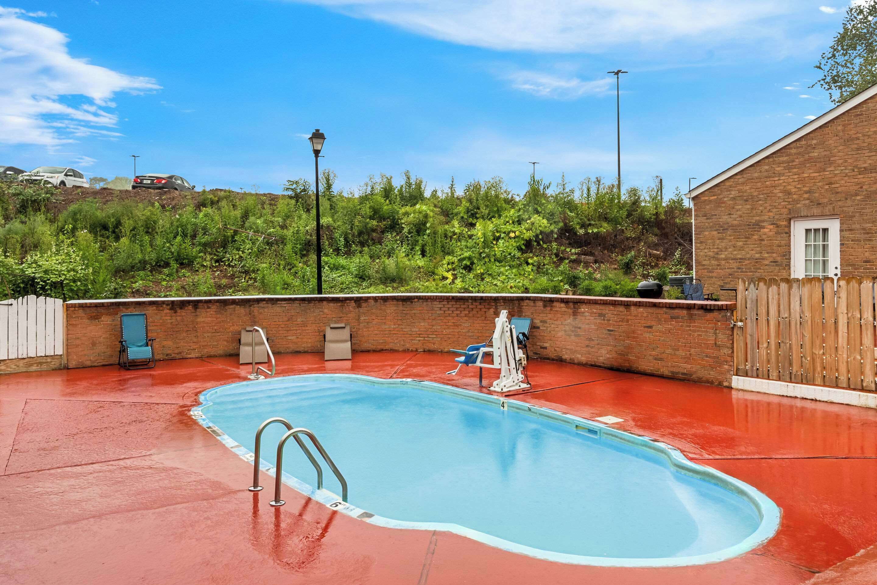 En säsongsöppen utomhuspool, parasoller och solstolar