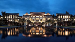 A large, multi-story hotel with a reflective pool in front.
