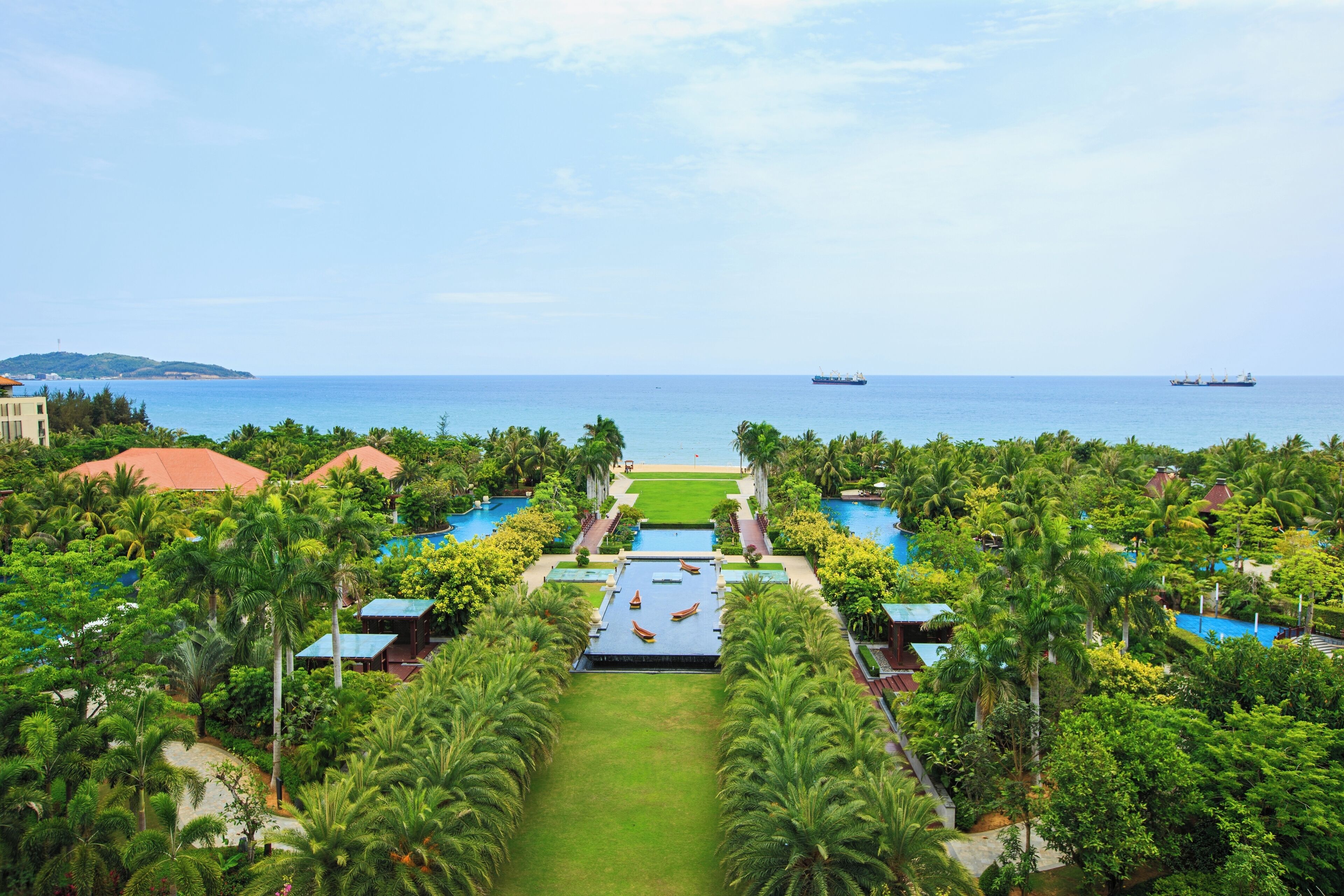 Un resort con piscina central, varias piscinas más pequeñas y vistas al mar.