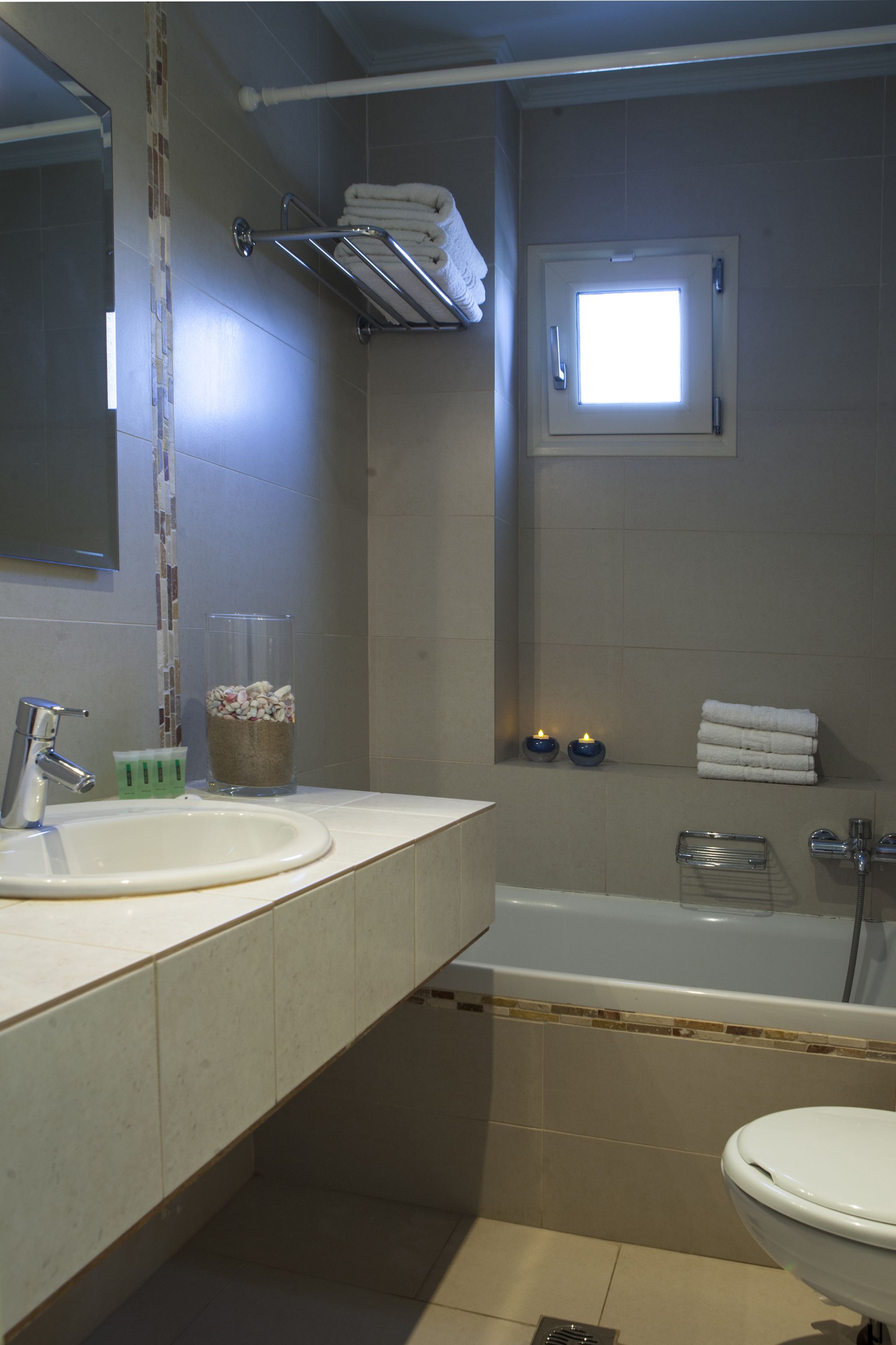 Un baño con lavamanos, espejo y bañera.