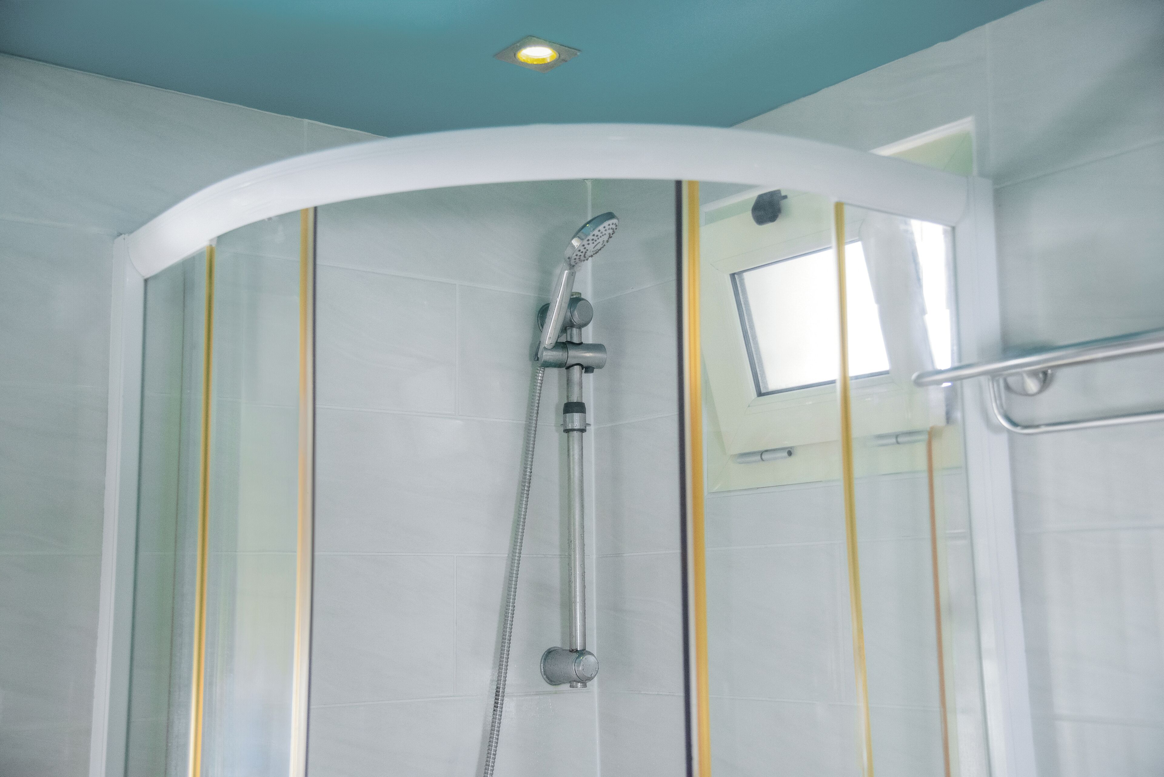 Eine Dusche mit gewölbter Decke und Handbrause.