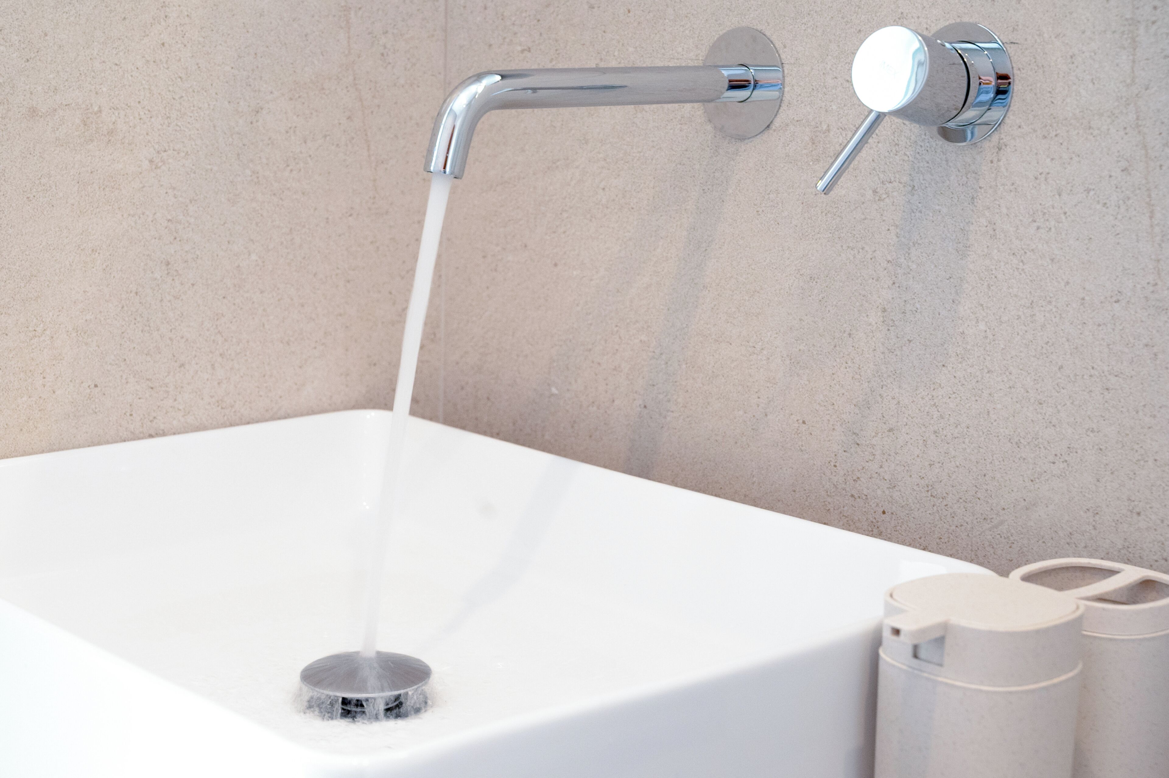 Ein modernes Badezimmer mit einer weißen Badewanne, einem Chrom-Wasserhahn und einer wandmontierten Armatur.