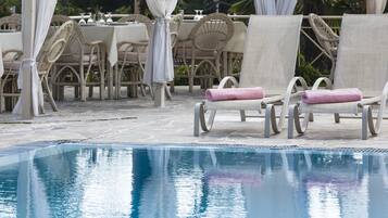 Un espace aménagé au bord de la piscine, avec des chaises longues et un coin salon abrité.