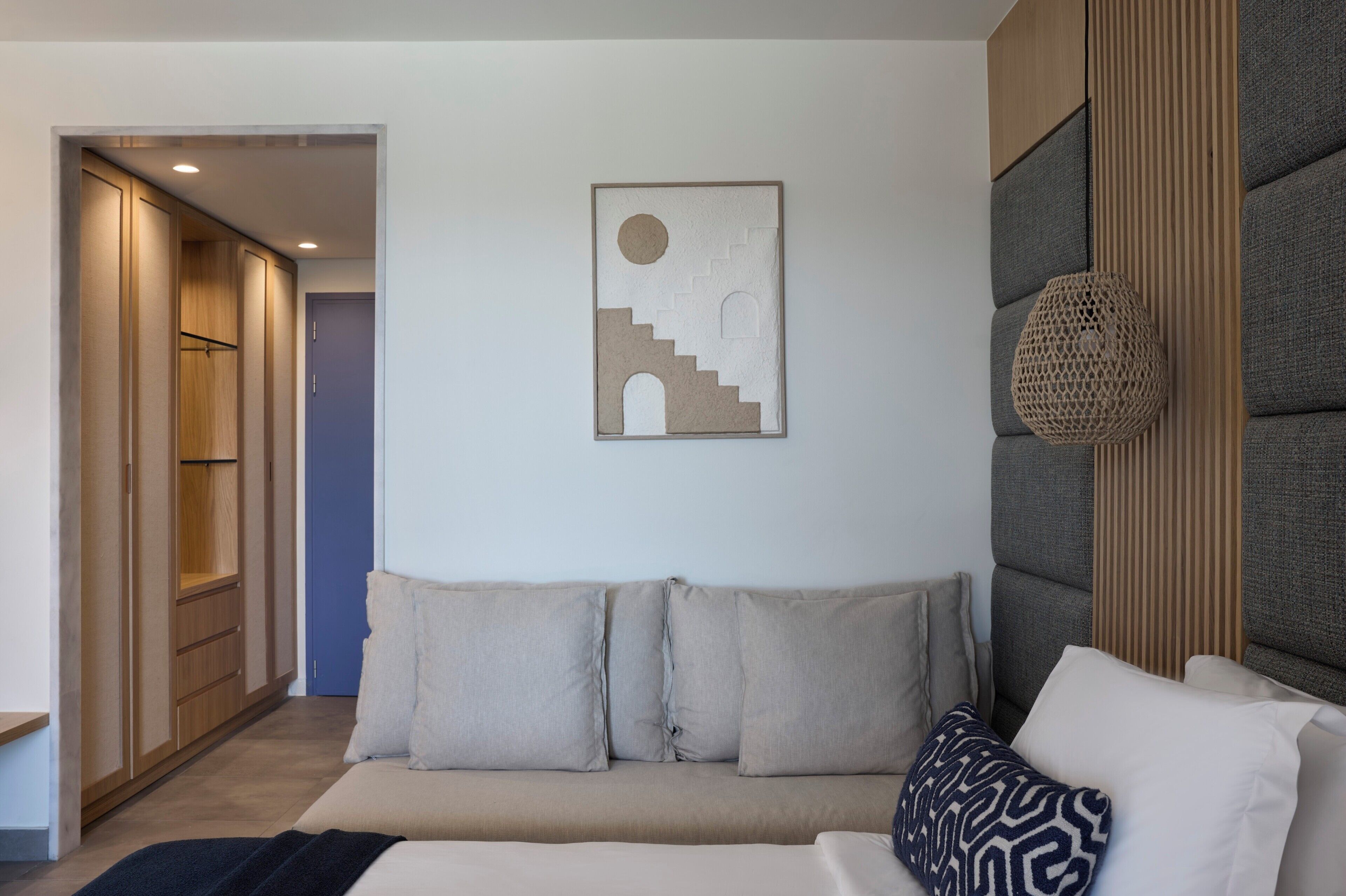 Una habitación moderna con un sofá, una obra de arte en la pared y un armario de madera.
