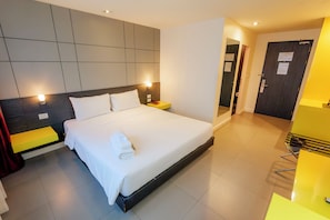 A hotel room with a large bed, bedside tables, a mirror, a door, and a bright yellow chair. - The Park Residence at Bangkok (Bangkok)