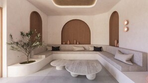 Un interior moderno con una zona de estar curvada, una mesa redonda central y una planta en maceta.