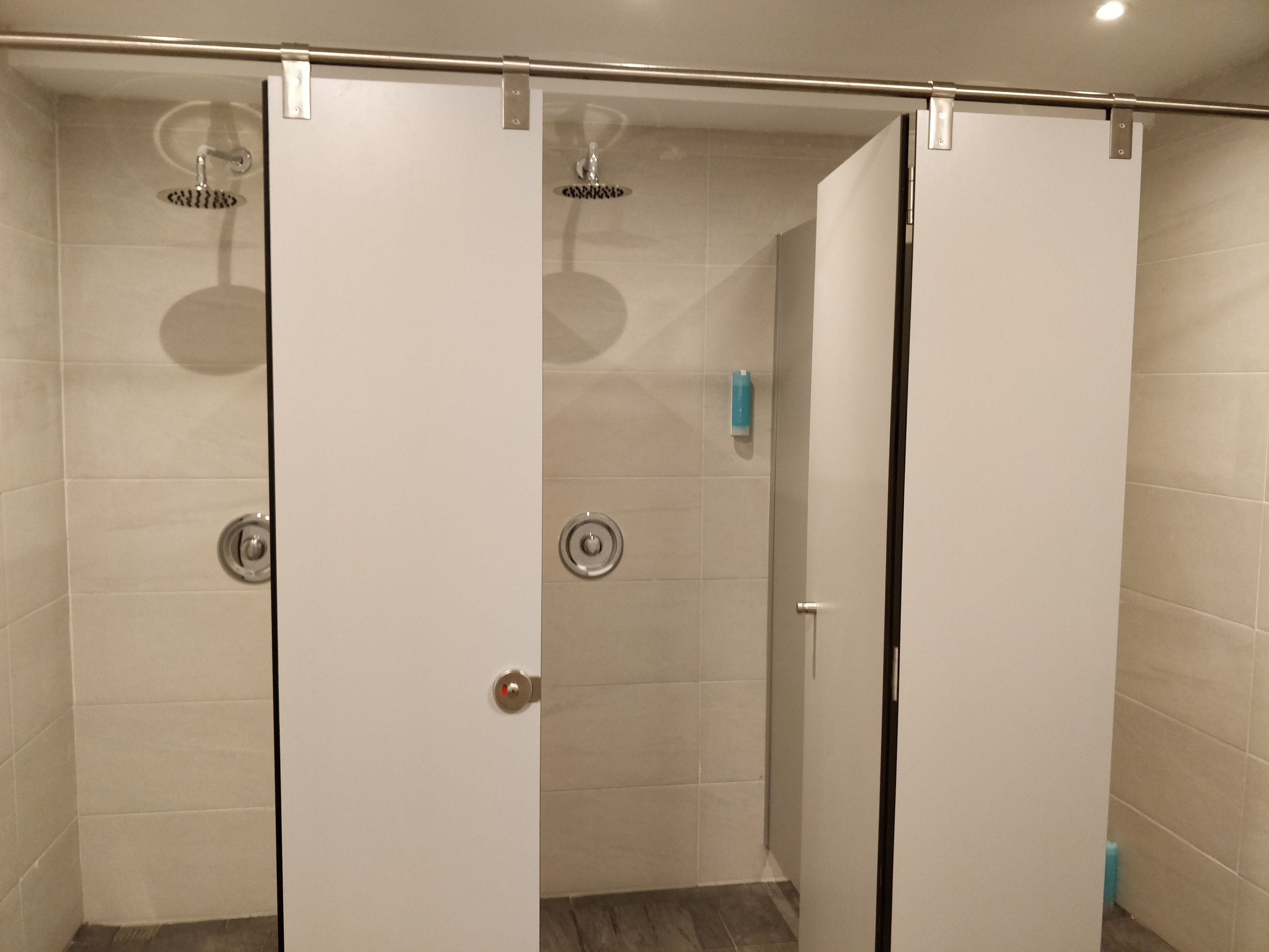 Un bagno con due cabine doccia, ciascuna con porta in vetro e soffione.