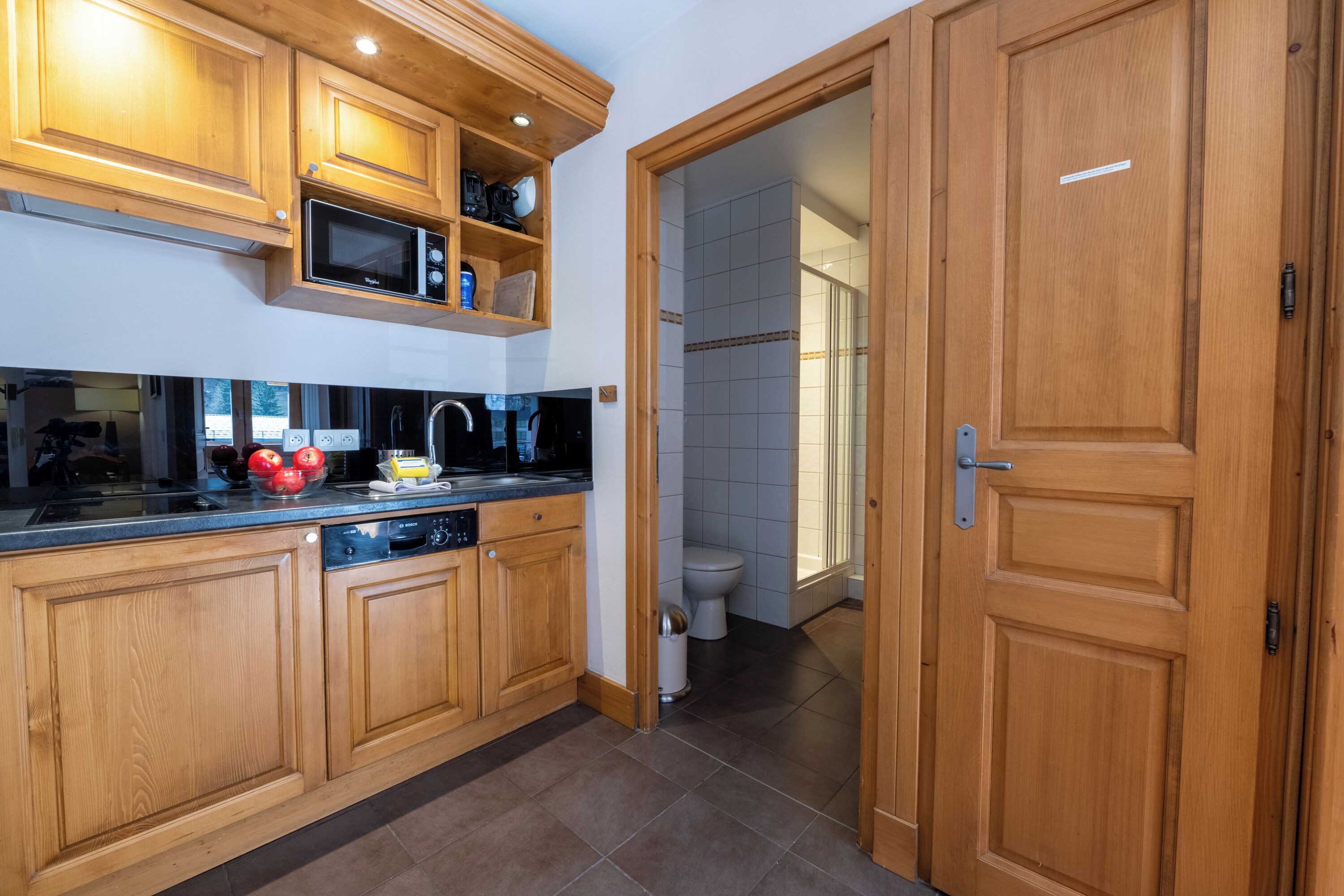 Una cucina con mobili in legno, un forno a microonde e un lavello.