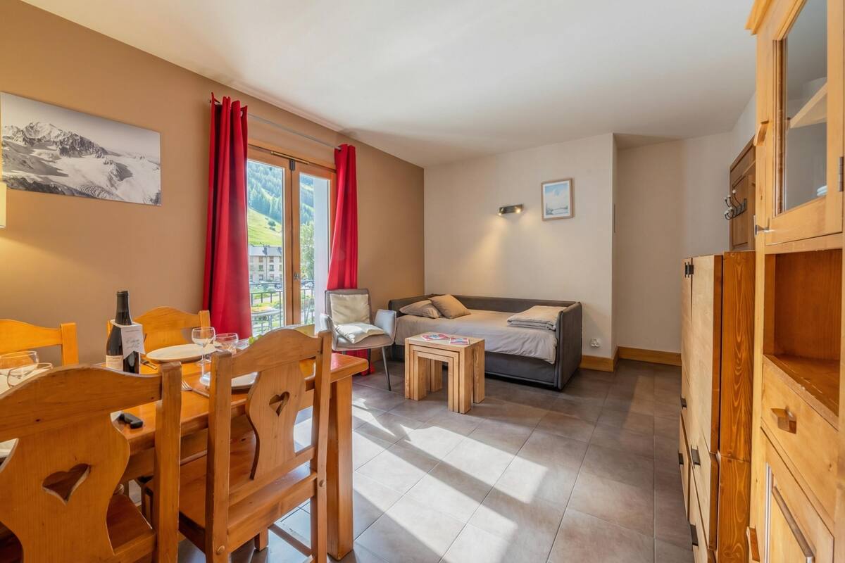Une pièce comprenant une table à manger, des chaises, un canapé, une petite table et un meuble.