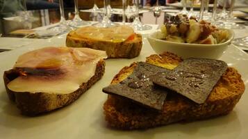 Una mesa con distintos alimentos y copas de vino.