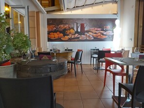A restaurant interior with tables, chairs, and a large menu display. - B&b Belveliero (Trapani)