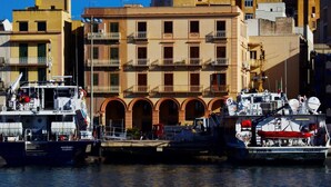 A waterfront building with multiple balconies and a docked boat. - B&b Belveliero (Trapani)