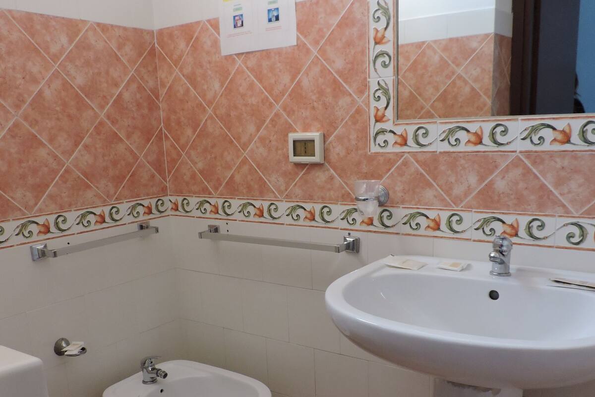 A bathroom with a toilet, bidet, and sink.