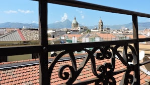 A cityscape with a prominent church and mountains in the background. - Hotel Concordia (Palermo)