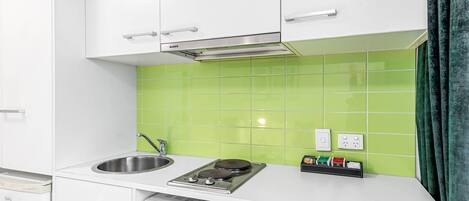A kitchen with white cabinets, a stainless steel sink, a microwave, and a gas stove.