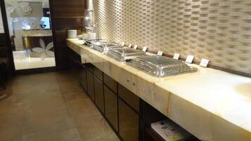Una cocina moderna con una encimera larga, varias estaciones de servicio y un salpicadero decorativo.