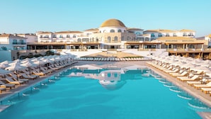 Ein Resort mit großem Pool, Liegestühlen und einem zentralen Gebäude mit Kuppel.