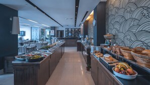 A buffet area with various food items and a decorative wall with a wave pattern. - Riva Resatbey Hotel (Adana)