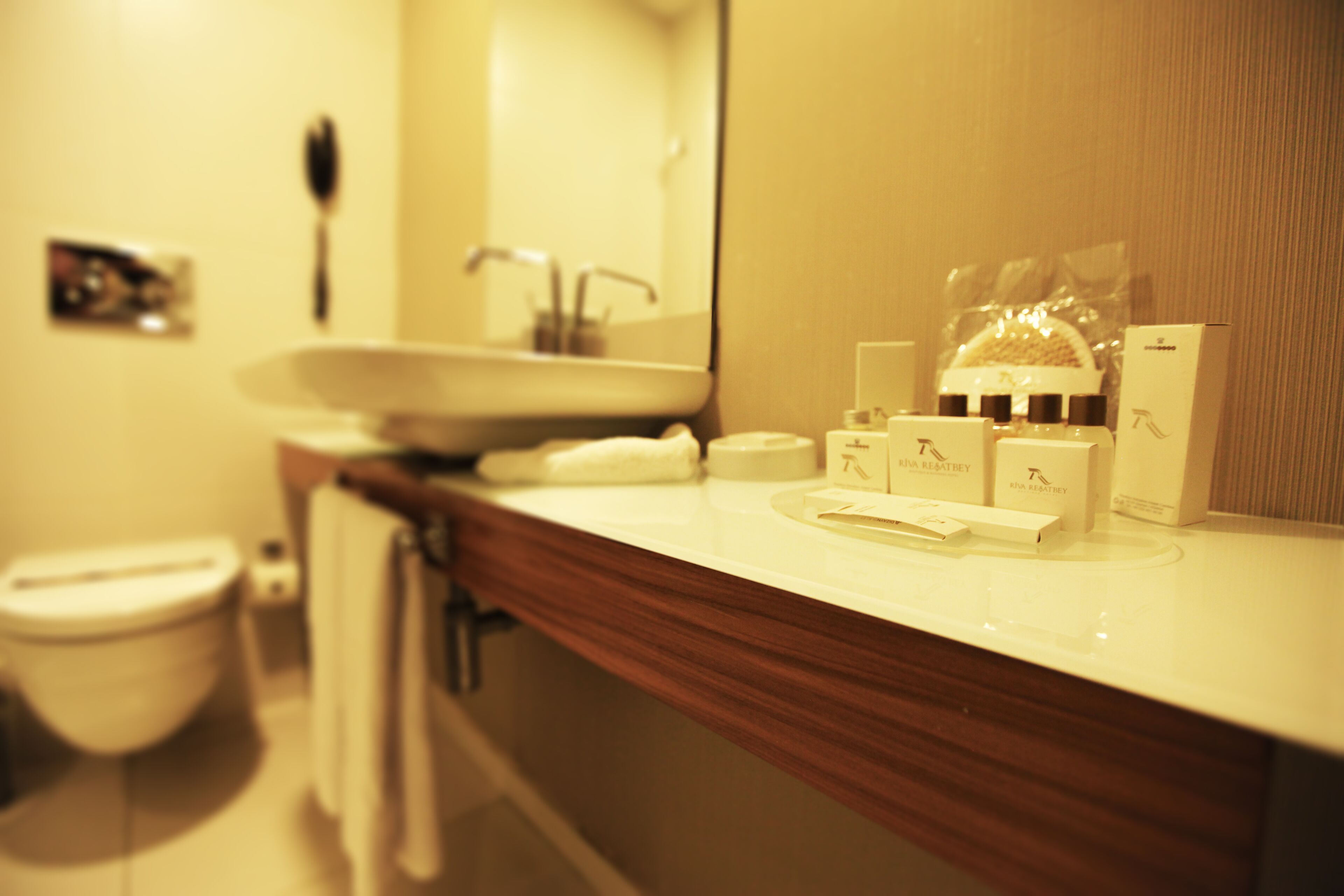 A bathroom with a sink, mirror, and toiletries.