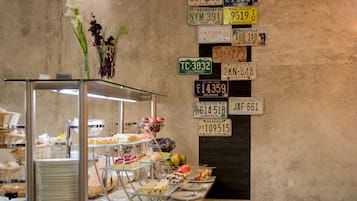 A buffet area with various food items and a wall displaying multiple license plates.