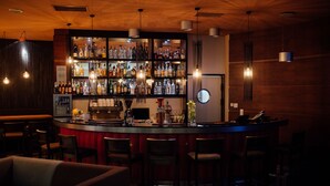 A bar area with a wooden interior, multiple shelves of bottles, and bar stools. - Haston City Hotel (Wroclaw)