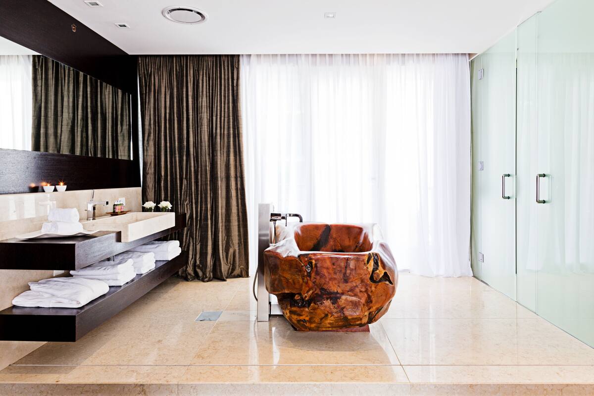 A modern bathroom with a vanity, a large mirror, a bathtub, and a glass shower enclosure.