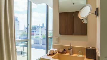 A modern bathroom with a large window, a built-in sink, and a mirror.