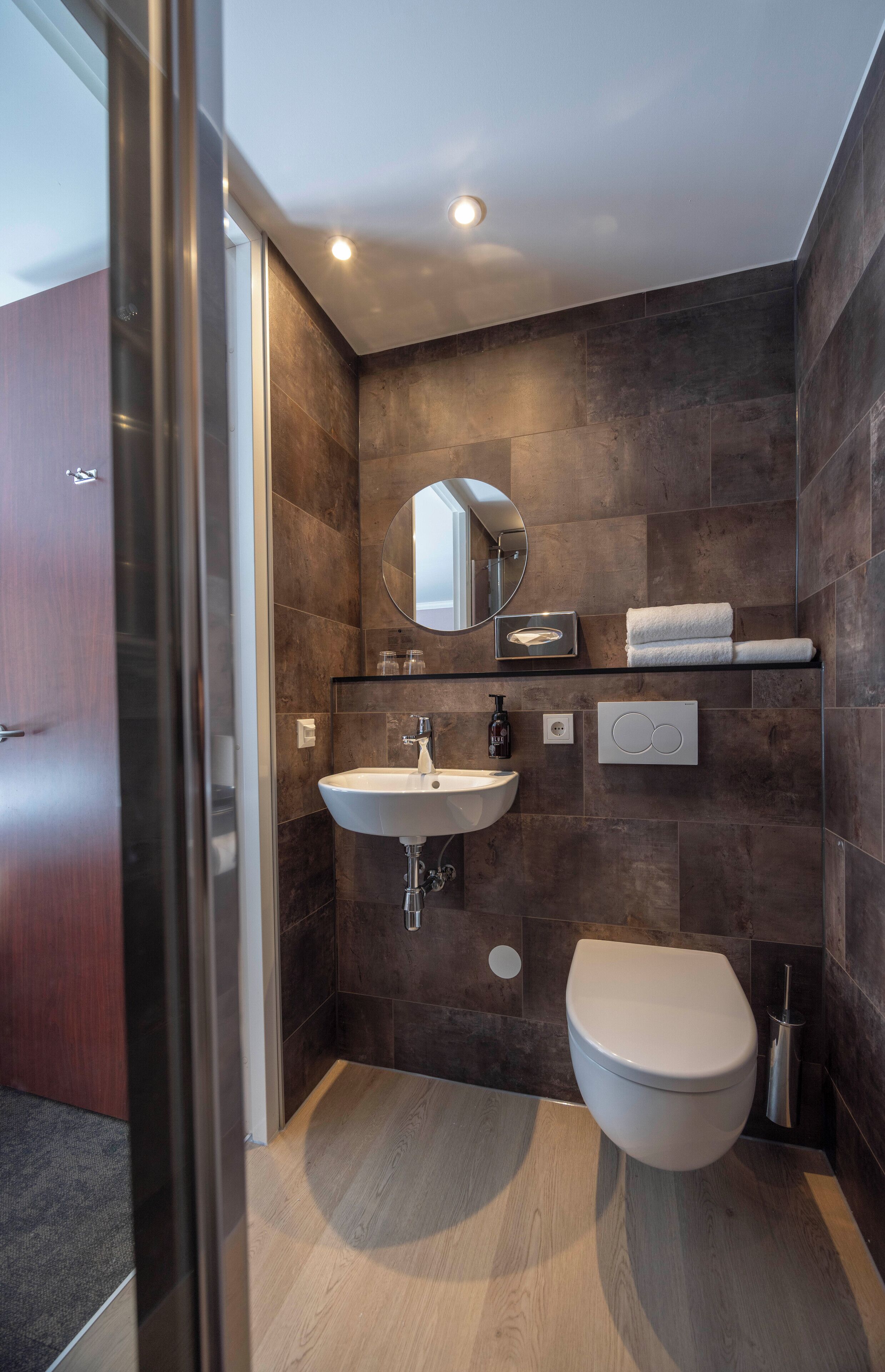 Un baño moderno con lavamanos integrado, inodoro y espejo.