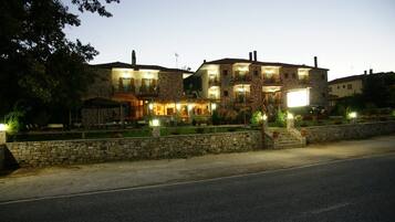 A stone building with multiple balconies and a well-lit entrance.