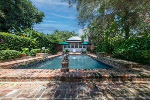 Una piscina al aire libre, sillones reclinables de piscina