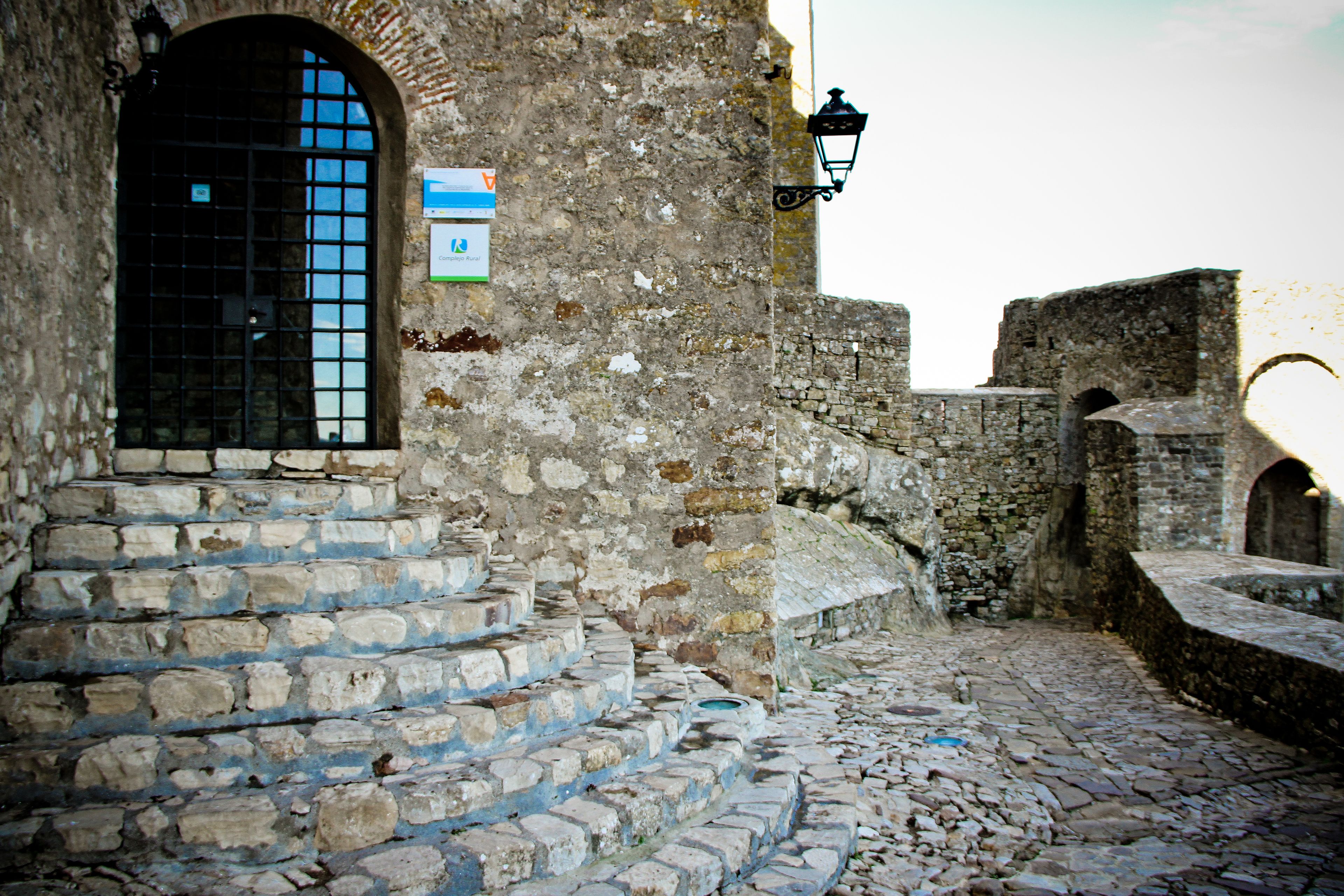 A stone staircase leading up to a building entrance with a sign above the door.