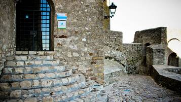 A stone staircase leading up to a building entrance with a sign above the door.