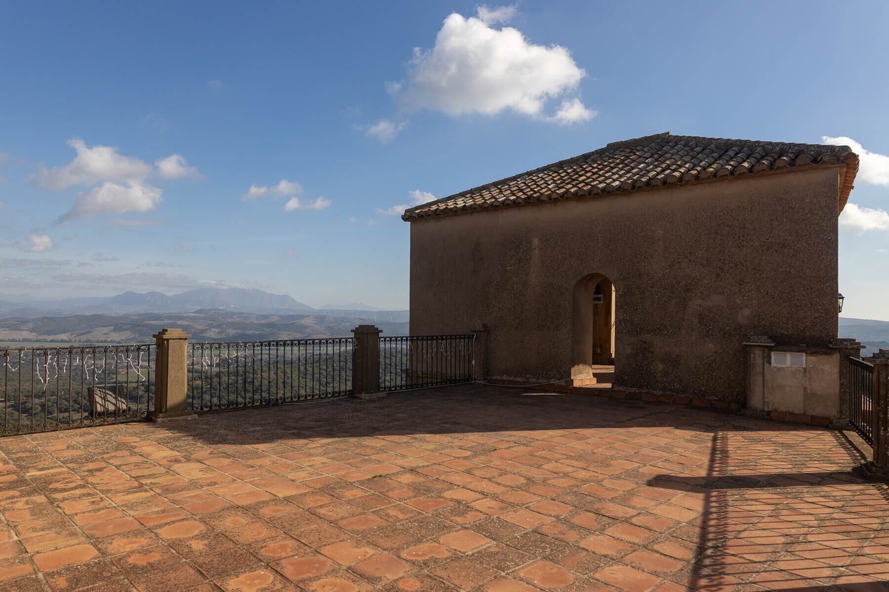 A small building with a tiled roof and a paved courtyard.