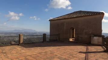 A small building with a tiled roof and a paved courtyard.