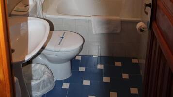 A bathroom with a white toilet, a white sink, a bathtub, and a shower curtain.