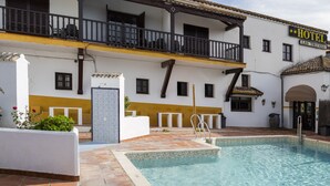 Un hotel con piscina, balcón y un letrero que dice "HOTEL LAS TRUCHAS".