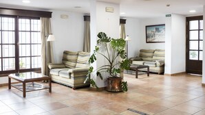 A hotel lobby with two sofas, a coffee table, and a potted plant. - TUGASA Sierra Y Cal (Olvera)