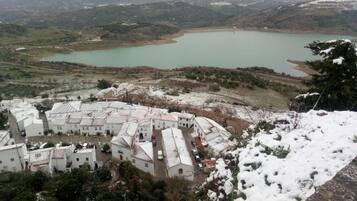 Un pueblo cubierto de nieve con edificios tradicionales y un lago al fondo.