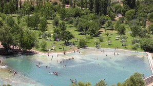 A large outdoor swimming area surrounded by trees and grassy areas. - TUGASA Hotel Arco de la Villa (Zahara de la Sierra)