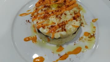 Un plato blanco con un alimento cubierto de salsa y especias.