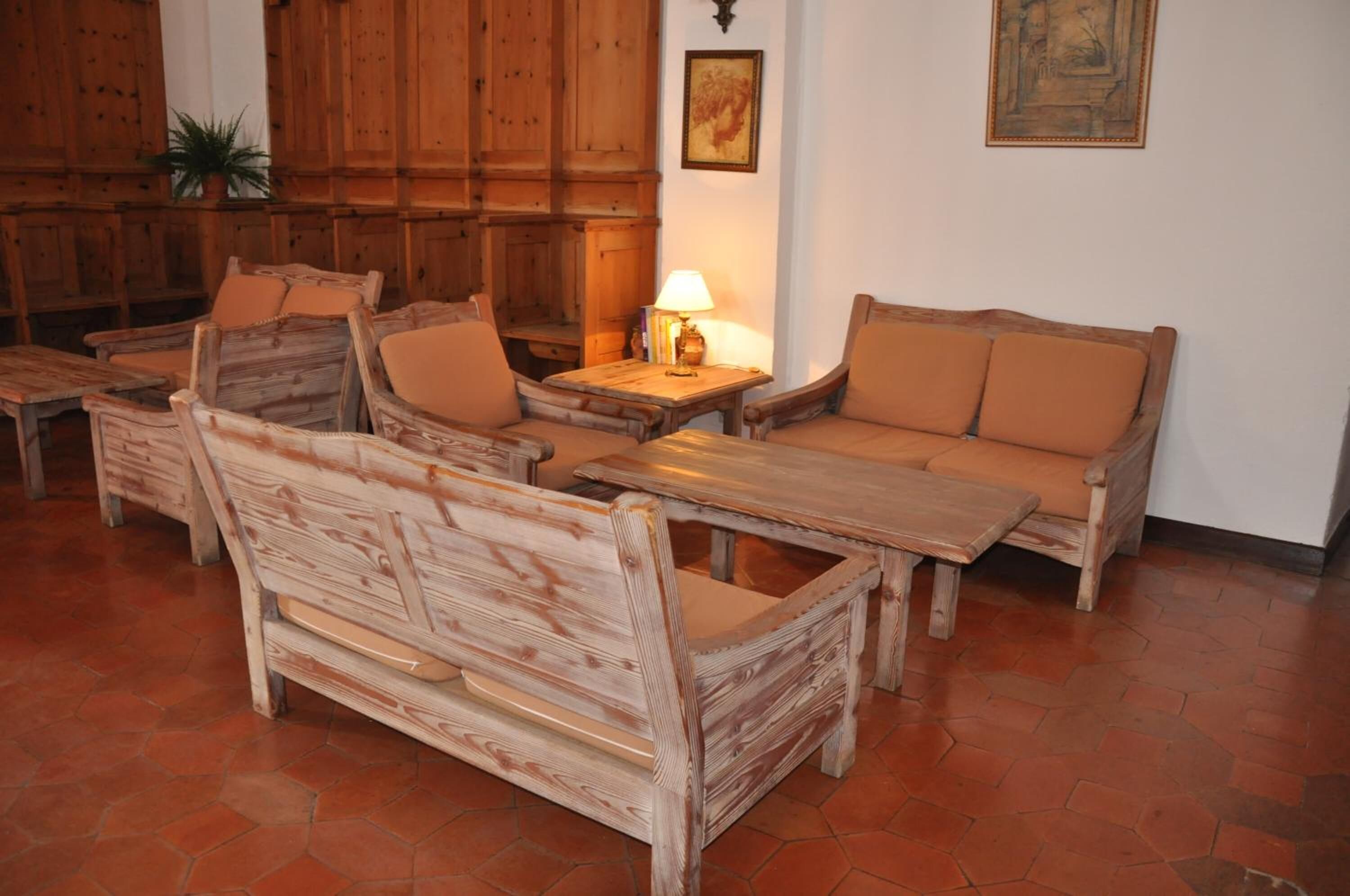A rustic wooden room with a sofa, chairs, and a small table.