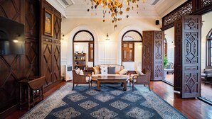 A spacious lobby with a large sofa set, a wooden coffee table, and a patterned rug. - Praya Palazzo (Bangkok)