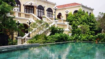 Una piscina al aire libre, sombrillas, tumbonas