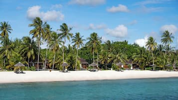 On the beach, white sand, sun-loungers, beach umbrellas